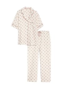 Baumwoll-Pyjama-Set mit einem kurzärmeligen Oberteil und langen Hosen. Heller rosa Hintergrund mit floralem Muster und kontrastierenden Besätzen.