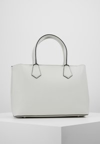 Sac à main en simili cuir blanc avec poignées courtes, forme angulaire, accents noirs contrastants le long des bords et texture lisse.
