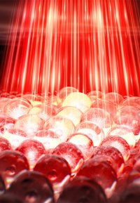 Red LED light beams shine over numerous translucent, spherical gel-like beads, creating a bright and textured visual field.