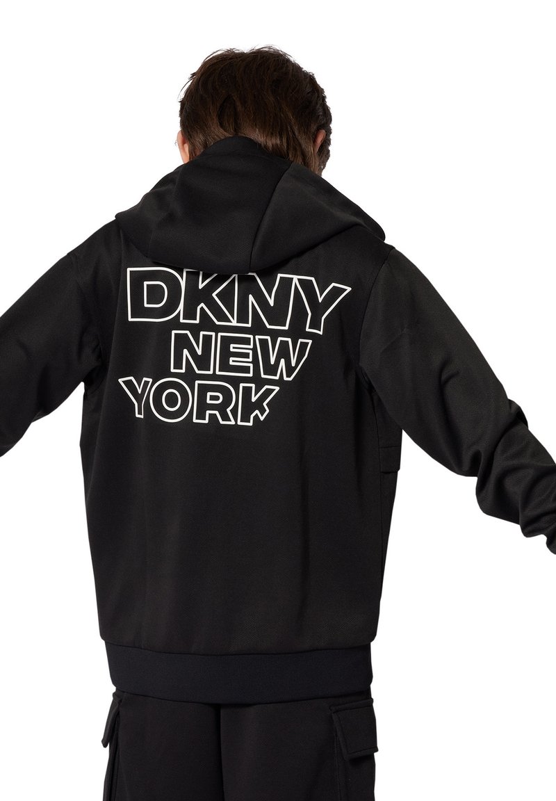 Felpa nera con cappuccio caratterizzata dalla scritta "DKNY NEW YORK" in grande formato bianco sul retro; tessuto testurizzato, vestibilità rilassata e orlo a coste.