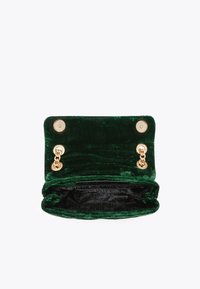 Groene fluwelen handtas met gouden accenten, drukknoopsluiting en kettingdetail. Binnenvoering van zwart gemusterd stof. Geopend uitzicht.