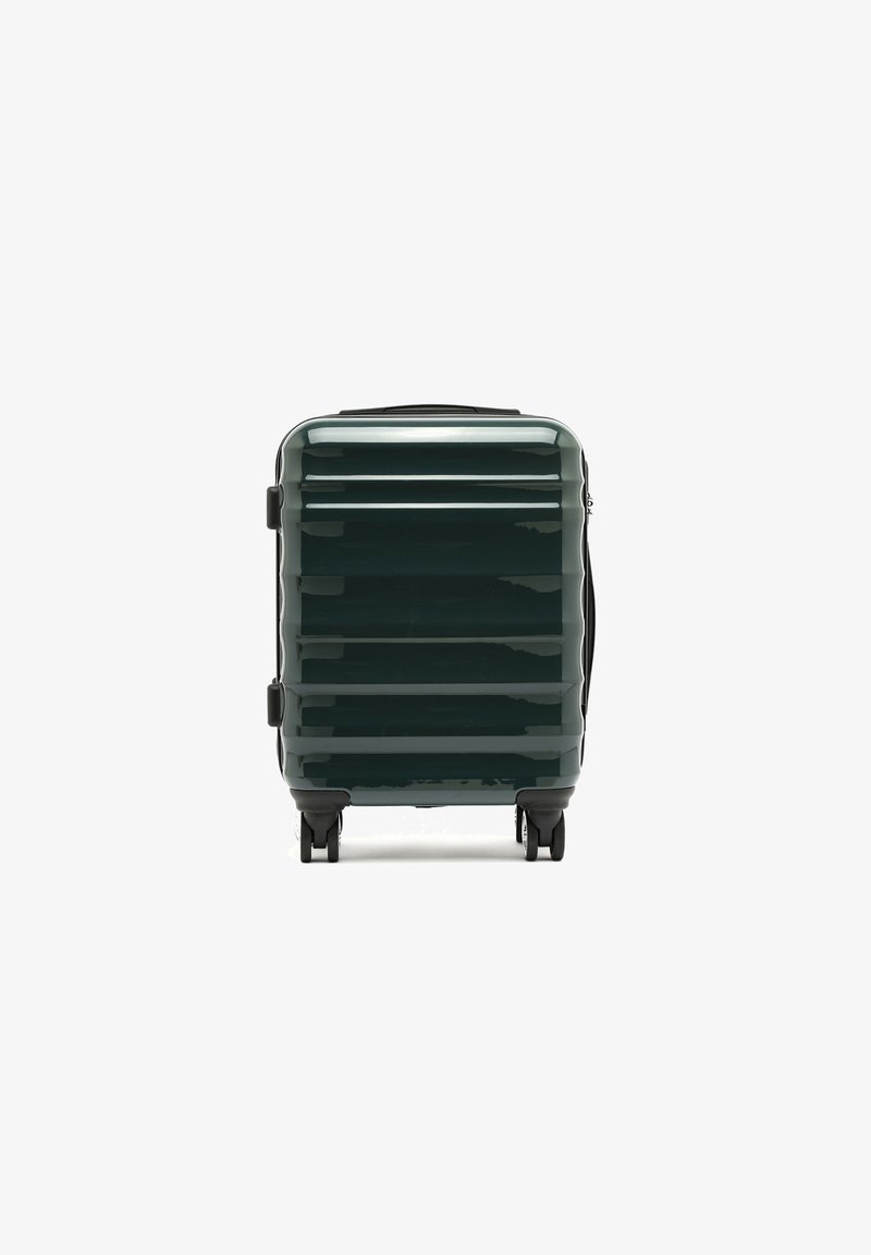 Tvrdý kufr v tmavě zelené barvě, s lesklým povrchem, vertikálními drážkami, černými komponenty a dvojitými koly pro snadnou manipulaci.