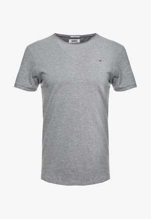 Szara koszulka z krótkim rękawem i okrągłym dekoltem, z małym logo Tommy Jeans na lewej piersi oraz widoczną metką marki wewnątrz kołnierza.