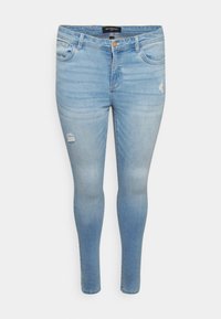 Jean skinny en denim bleu clair avec un effet délavé, présentant des détails déchirés sur les cuisses et un design classique à cinq poches.