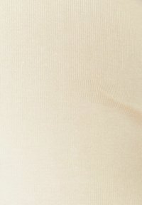 Beigenvärinen resoribikangas, jossa on sileä pinta ja pystysuoria viivoja. Materiaali vaikuttaa joustavalta ja kevyeltä.