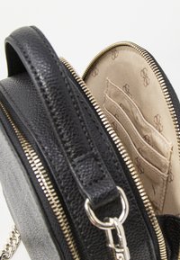 Borsa a tracolla rotonda nera in pelle texture, con zip dorata, interno beige con più slot per schede e hardware argentato.