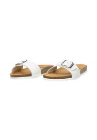 White slide sandals with a silver buckle and cork soles. The design features an open toe and a minimalist style on a white background.