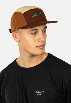 Brown and beige cap with a flat brim, featuring green embroidered text "Reell." Made of soft fabric, showcasing a color-block design.