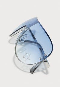 Blaue Gradient Sonnenbrille mit gebogenen Gläsern, silbernem Metallrahmen und strukturierten Sternverzierungen. Enthält klare Nasenpolster und schwarze Bügel.