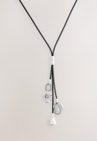 Schwarzes Kordel-Collier mit silbernen Akzenten, das drei Anhänger enthält: eine Perle, eine strukturierte Kugel und kreisförmige Designs, alle mit unterschiedlichen Oberflächen.