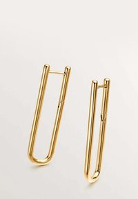 Pendientes de metal en tono dorado con forma de alfiler de seguridad alargado, con una textura suave y un diseño abierto que cuenta con un mecanismo de cierre con bisagra.