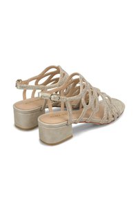 Sandali beige con cinturino, decorati e con tacco basso a blocco. Il design open-toe presenta una soletta imbottita e una cinghia alla caviglia regolabile.