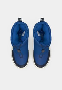 Chaussures isolées bleues avec une doublure douce et texturée, un dispositif de fermeture à bascule élastique et un accent contrastant en bleu marine foncé au niveau des orteils.