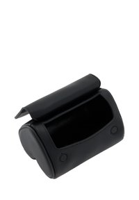 Sort læderhåndtaske med en rund form, en klaplukning og en glat tekstur. Har to dekorative knapper på frontpanelet.