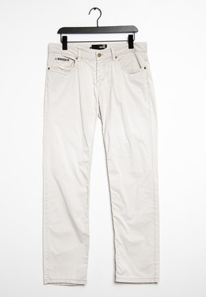 Jasnobeżowe spodnie o prostych nogawkach wiszące na czarnym wieszaku, wyposażone w frontowy guzik, zamek błyskawiczny oraz pięciokieszeniowy design.