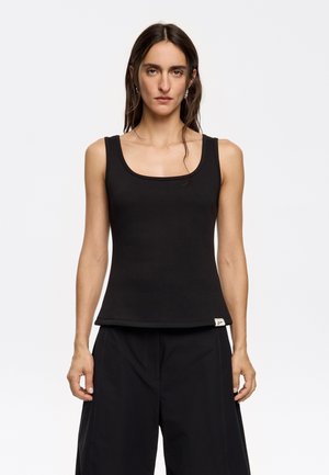 Black sleeveless tank top made of a smooth, stretchy fabric. Features a square neckline and a small brand label at the hem.