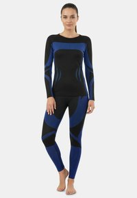 Black and blue athletic set featuring a long-sleeve top and leggings. The fabric has a smooth texture with contrasting wave patterns.