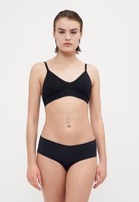 Black lingerie set includes a triangular bralette with thin straps and a stretchy band, paired with matching hipster briefs.