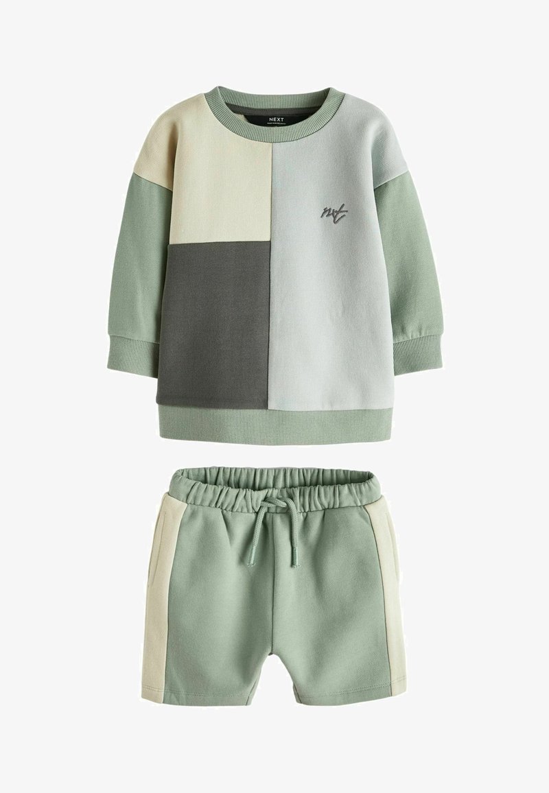 Kaksiosaline komplekt, mis sisaldab pikkade varrukatega toppi ja lühikesi pükse. Pehme puuvillane kangas, piparmündiroheline, beeži ja hallide plokkidega ning väikese logoga.