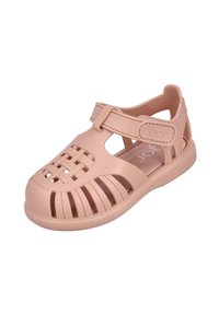 Sandalias infantiles rosas hechas de plástico flexible, con diseño trenzado y ranurado, correa ajustable y lados abiertos para ventilación.
