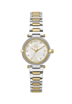 Hõbedase ja kullatooni metallist käekell, millel on ümmargune valge pärlmutter-kellaplaat, rooma numbrid ja kristallaktsendid lingiga käevõrurihmal.