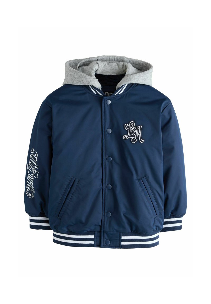 Marineblaue Bomberjacke mit grauem Kapuzenfell, weißen gestreiften Bündchen und Taillenbund, mit "LA" Stickerei auf der Brust und Schriftzugdetail am Ärmel.