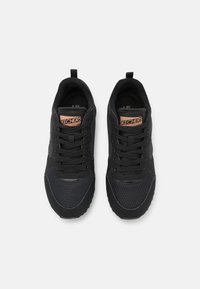 Ett par svarta Skechers-sneakers med detaljer i mesh och läder, svarta skor, och en brun Skechers-logotyp på plösen, sedd uppifrån.