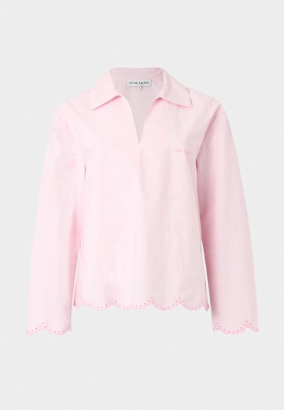 Ανοιχτό ροζ μακρυμάνικο μπλουζάκι με φαρδύ γιακά, V-λαιμόκοψη, κυματιστό τελείωμα και μανσέτες, καθώς και διακριτικές κεντητές λεπτομέρειες.