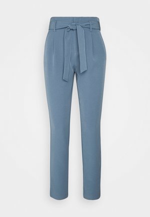 Hoch taillierte, hellblaue, schmal zulaufende Hose mit gebundenem Stoffgürtel an der Taille und seitlichen Taschen, auf einem einfarbigen Hintergrund dargestellt.