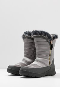 Botas grises impermeables con un diseño acolchado, ribete de piel sintética suave, cremallera lateral y suela de goma texturizada para mayor agarre.
