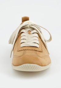 Helle Leder-Sneakers mit runder Spitze, strukturiertem Obermaterial, beigen Schnürsenkeln und einer weißen Gummisohle. Verfügt über eine dekorative Naht entlang der Kanten.