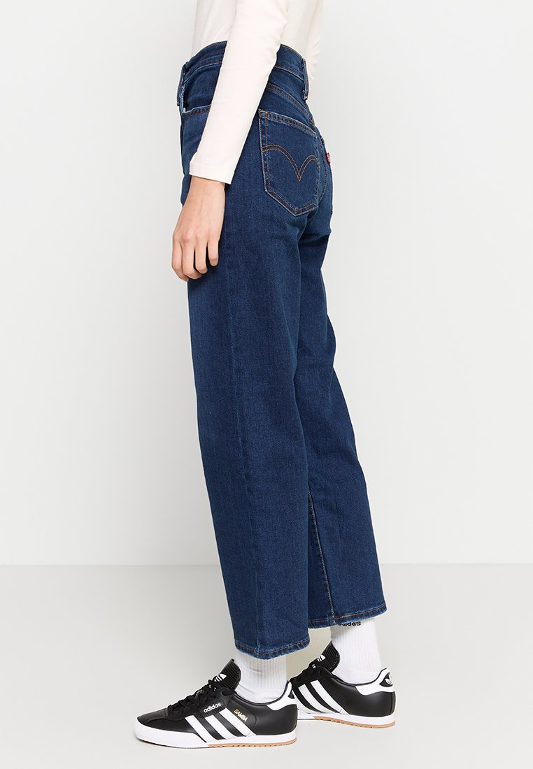 Jeans in denim blu scuro a vita alta con un fit rilassato, dotati di tasche frontali e di un classico etichetta Levi's sulla tasca posteriore.