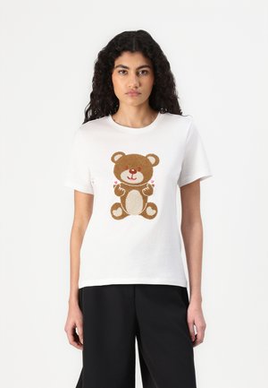 Hvit bomulls T-skjorte med en brun teddy-bjørn grafikk med hjerter; kort ermer, rund hals og avslappet passform.
