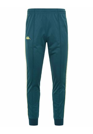 Pantaloni da jogging teal realizzati in tessuto morbido, con strisce laterali gialle e un piccolo logo sulla coscia sinistra. Vita elasticizzata e polsini.