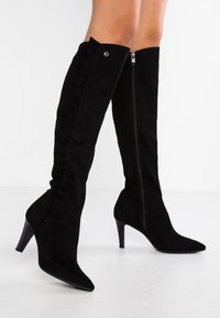 Schwarze Wildleder-Overknee-Stiefel mit spitzer Zehenpartie, schlanker Stilettoabsatz, seitlichem Reißverschluss und vertikalen Nahtdetails entlang des Beins.