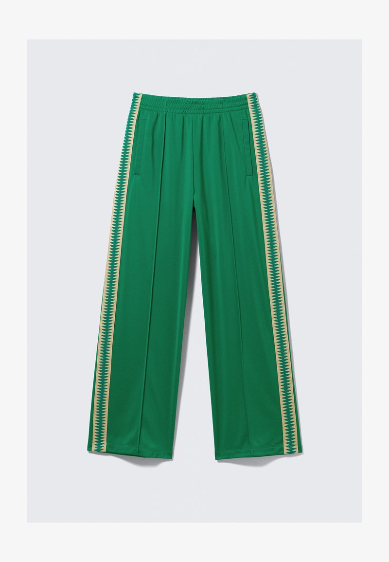 Zielone spodnie sportowe z elastycznym pasem, wyposażone w boczne kieszenie oraz pionowe paski w żółtym kolorze z wzorem zygzaków. Gładka tekstura.