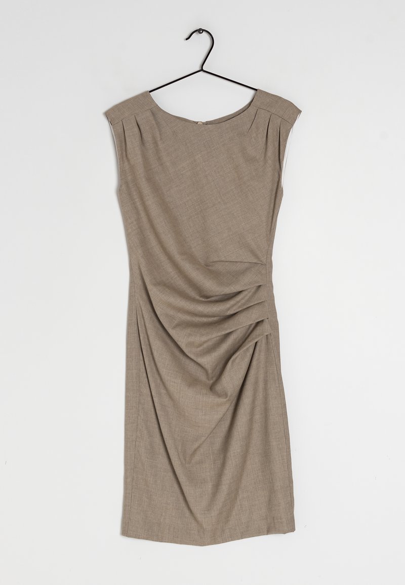 Vestido sin mangas beige con escote redondeado, detalles de hombros con pliegues y diseño drapeado en el costado, colgado de un gancho negro sobre un fondo blanco.