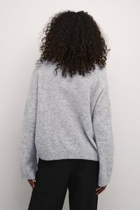 Grijze gebreide trui met een loose fit, verlaagde schouders en een geribde onderrand. Zachte textuur en casual lengte, geschikt voor het dragen in lagen.