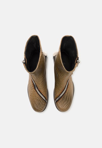 Botine ankle din piele cu embossing de crocodil, de culoare maro, cu căptușeală neagră, având un fermoar lateral proeminent și o siluetă elegantă.