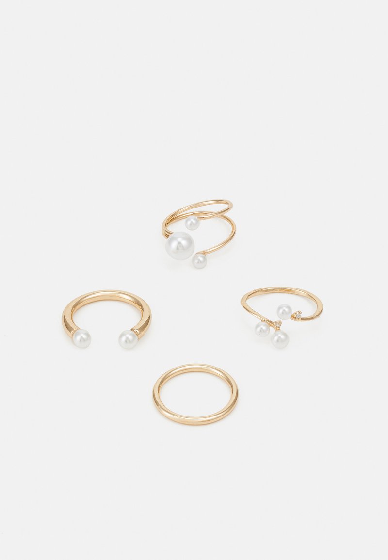 Quattro anelli realizzati in metallo color oro, due dei quali con perle bianche. Un anello ha una semplice fascia, mentre un altro presenta un design a spirale con perle.