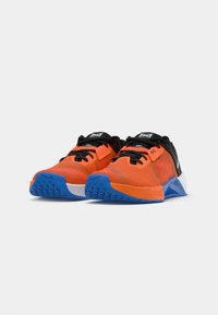 Sportssko med et strålende orange mesh-overdel, sorte detaljer, blå ydersål og hvid mellemsål; designet til ydeevne og komfort.
