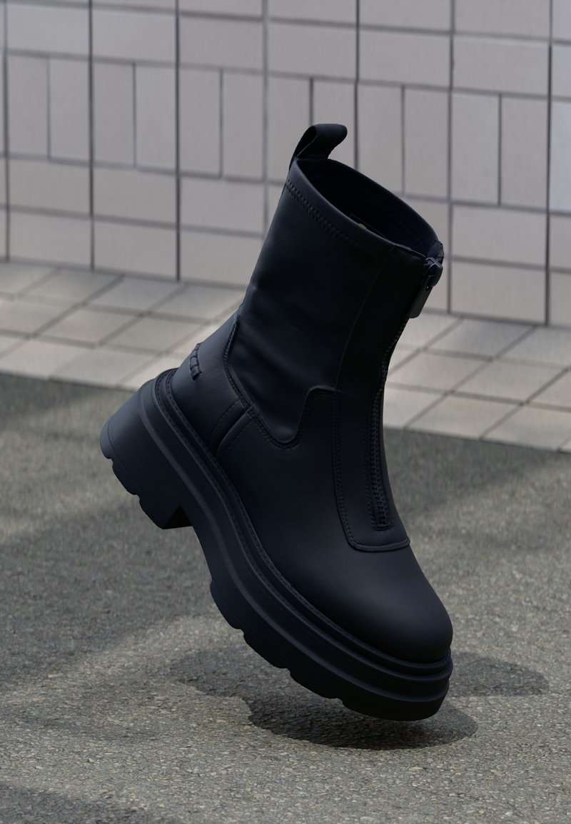 Mustast siledast nahast pahkluu saabased, millel on külgmine tõmblukk, paks tald ning kandmiseks mugav sang.