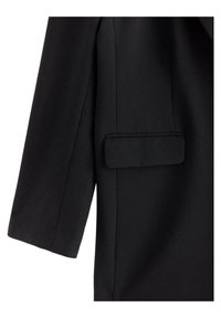 Blazer nero caratterizzato da un tessuto strutturato, forma sagomata e una tasca con patta singola sul lato sinistro della giacca.