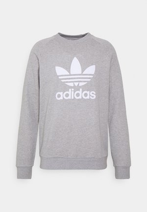 Jasnoszara bluza Adidas z długim rękawem, z prążkowanymi ściągaczami na mankietach i u dołu, z dużym białym logo koniczyny i napisem "adidas" na przodzie.
