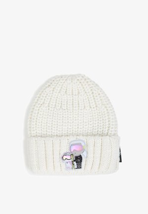 Bonnet blanc en tricot avec un bord replié, présentant un petit patch avec deux skieurs dessinés portant des lunettes de protection et tenant des bâtons de ski.