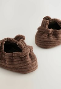 Bruna texturerade tofflor med ribbad design och samlad topp. Fodret har ett mörkt rutmönster. Mjukt, mysigt tyg.