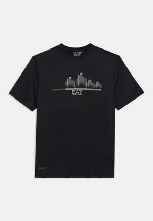 Camiseta negra de manga corta con gráfico de línea del horizonte de la ciudad en plata, texto "RIDE YOUR CITY" y logo EA7 Emporio Armani en el centro delantero.