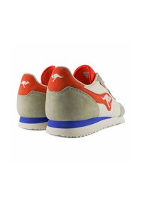 Sneaker beige con accenti arancioni e blu, caratterizzate da una morbida texture in suede, suola piatta e logo di canguro sul tallone.