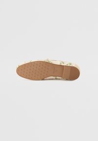 Virágmintás hímzett slip-on cipő, puha rózsaszín textil felsőrésszel, texturált bézs talppal és lekerekített orral. A minta zöld és rózsaszín színeket tartalmaz.