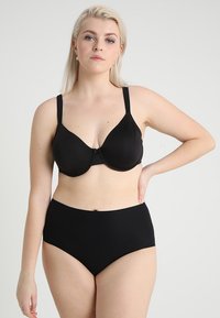 Black bra with molded cups and adjustable straps, paired with high-waisted black panties. Smooth fabric texture, seamless design.